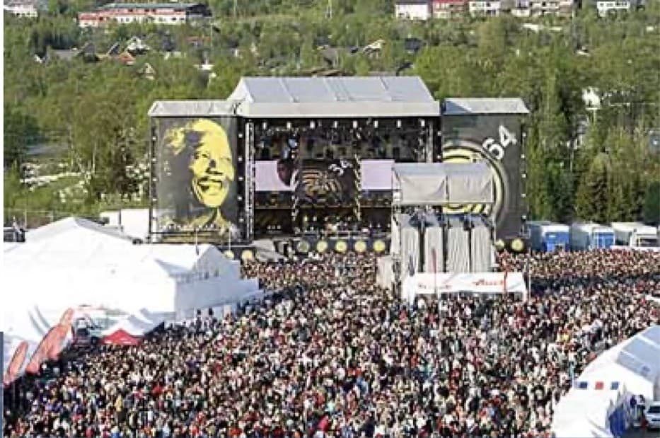 A 46664 benefit concert, with Nelson Mandela's portrait on the stage screens above the crowd